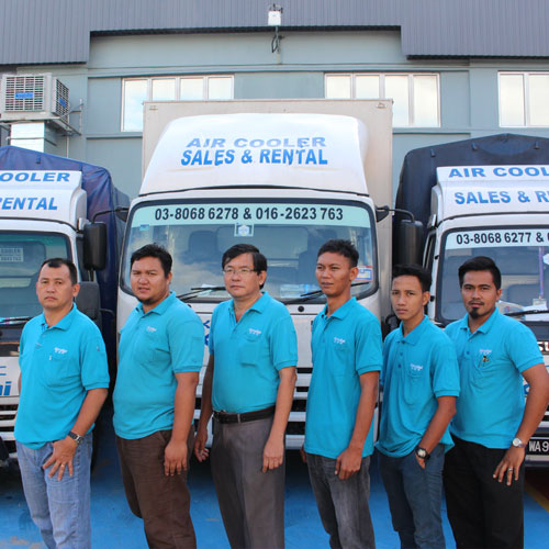Kpacific team in cyan uniforms in front of branded service vehicles